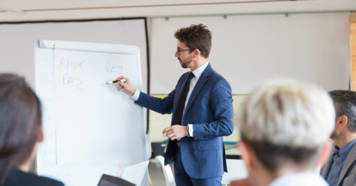 man writing on board