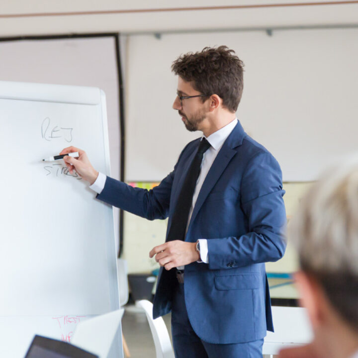 man writing on board